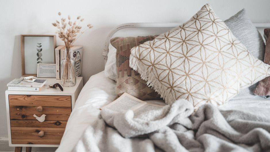 Bedroom bed with layered linen throw pillows in natural oatmeal tones